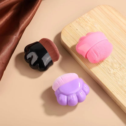 Three small paw-print shaped pet balm brushes with soft heads in plastic storage boxes
