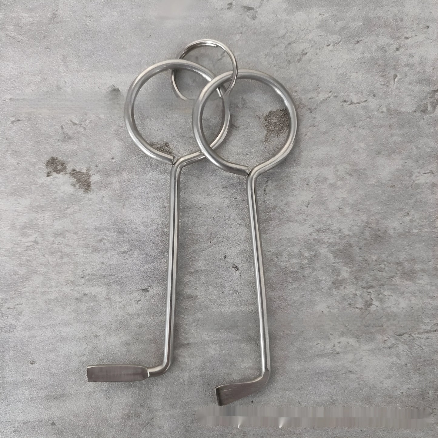 Two silver alloy wrench tools from a portable universal family set on a plain background.