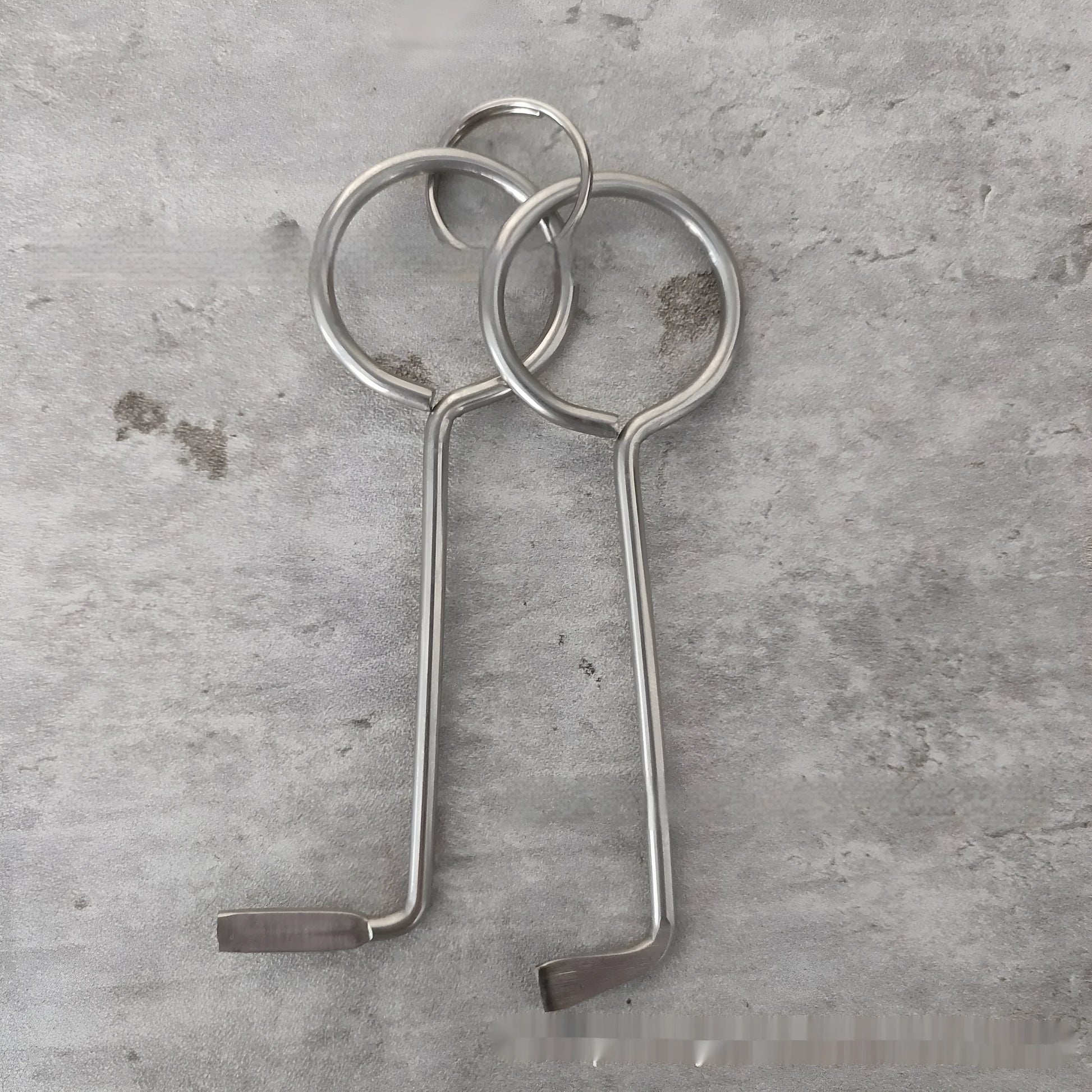 Two silver alloy wrench tools from a portable universal family set on a plain background.