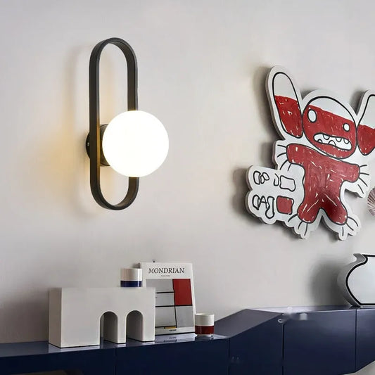 Minimalist wall lamp in black or gold finish with glass shade and 12W tri-colour LED lighting