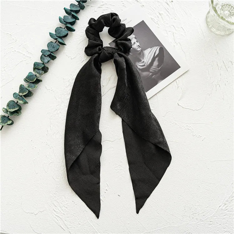 Long green ribbon hair tie with large intestine ring and floral pattern, laid flat showing 65cm length