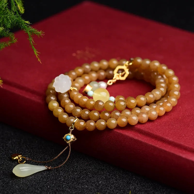Women's bracelet with green pine beads, beeswax elements, leaf shapes, and sequin accents