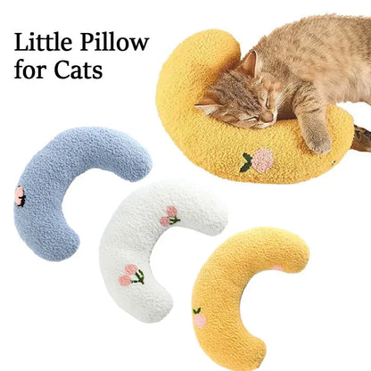 White U-shaped pet pillow measuring 27cm with raised rim supporting small cat's neck and back