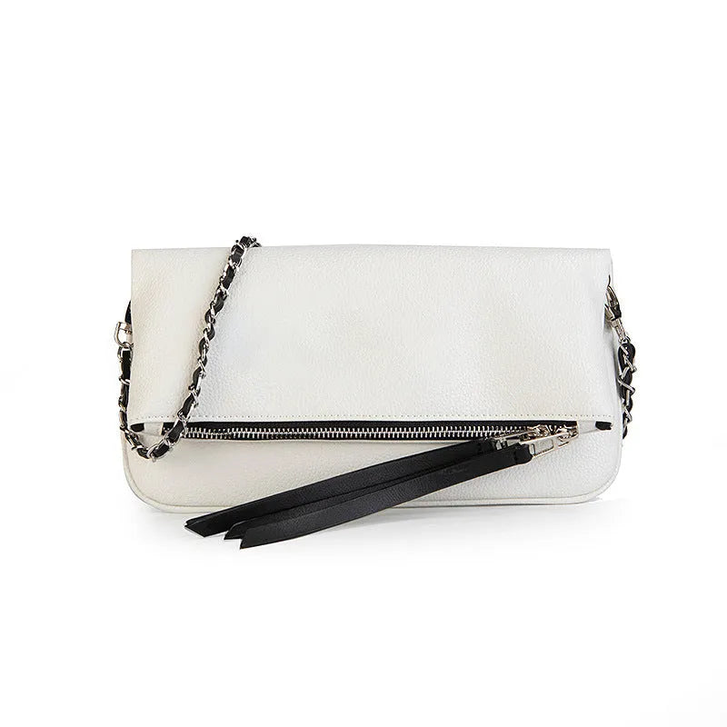 Soft black PU leather women's clutch bag with a gold chain strap, shown held and worn cross-body.