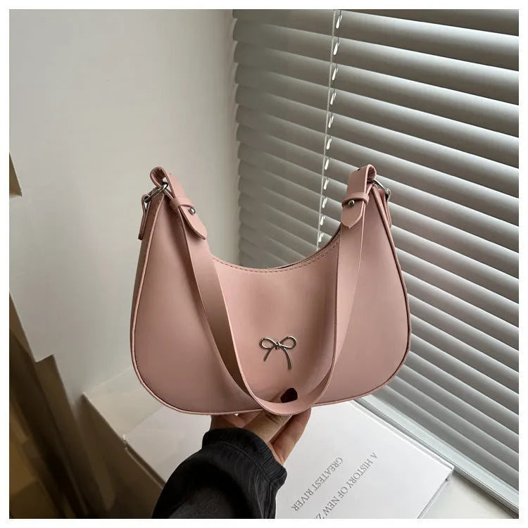 Women's silver dumpling-shaped PU crossbody bag showing front sandwich pocket and single shoulder strap.