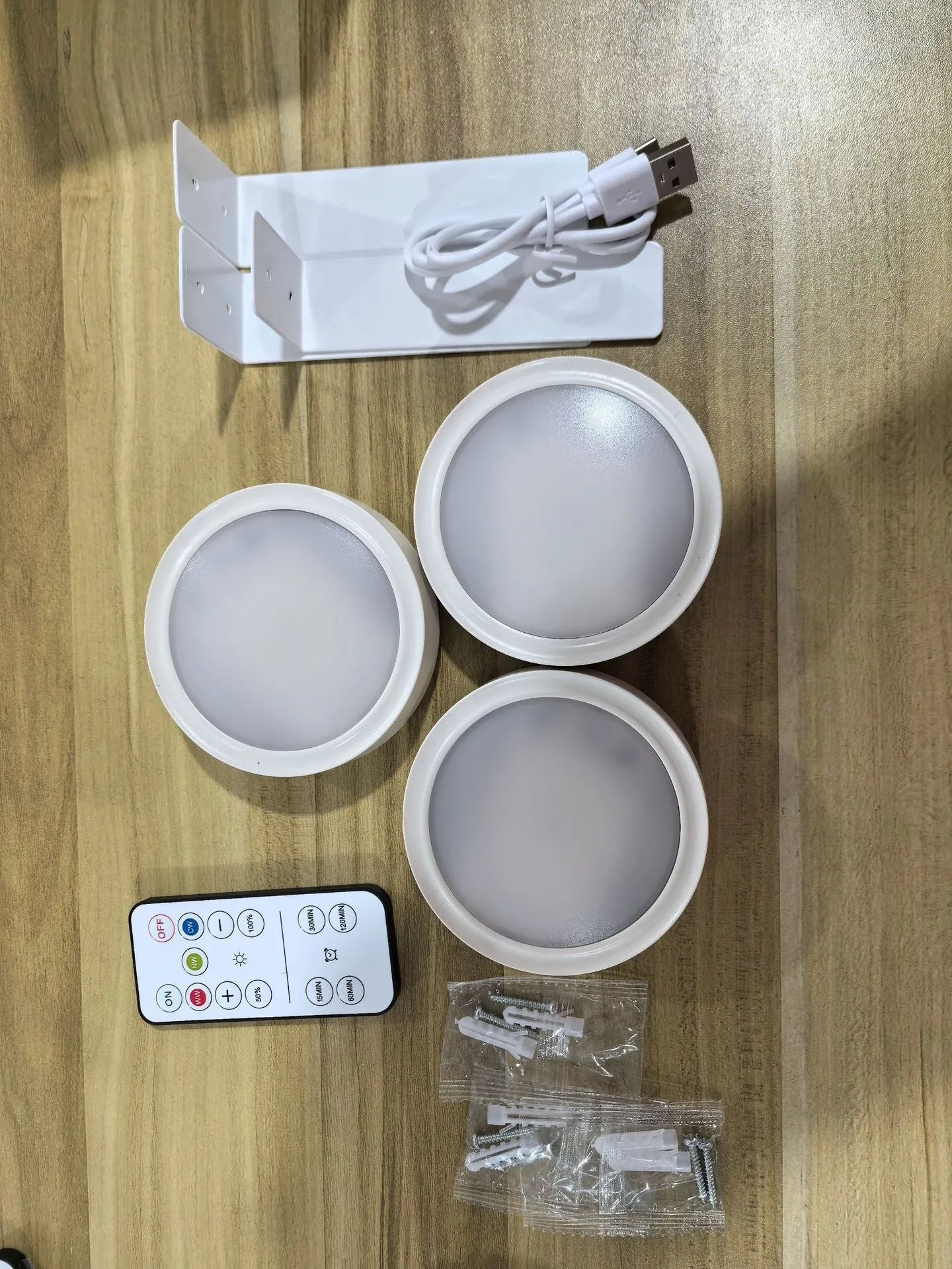 Black magnetic LED painting lamp with remote control on a white wall.