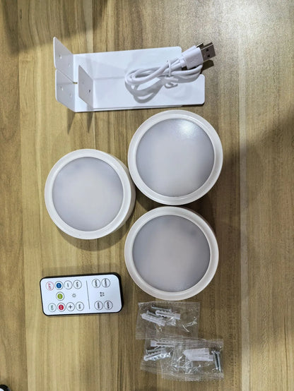 Black magnetic LED painting lamp with remote control on a white wall.