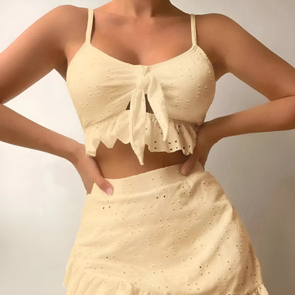 Women's white split hip skirt three-piece bikini swimsuit set on a mannequin.
