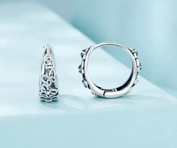 Sterling silver retro hollow butterfly earrings with zircon stones on a white background.