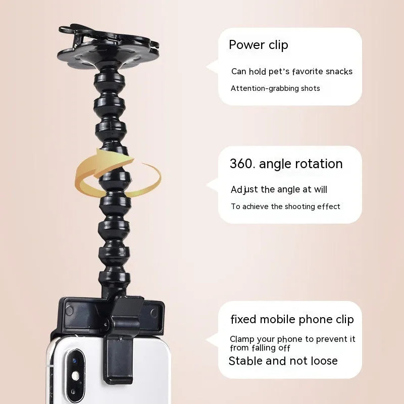 Black plastic pet photography tool attached to mobile phone with treat clip extended