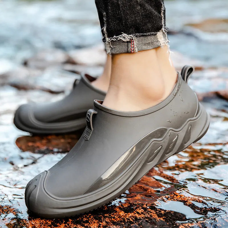 Men's short black plastic rain boots showing casual design and waterproof construction
