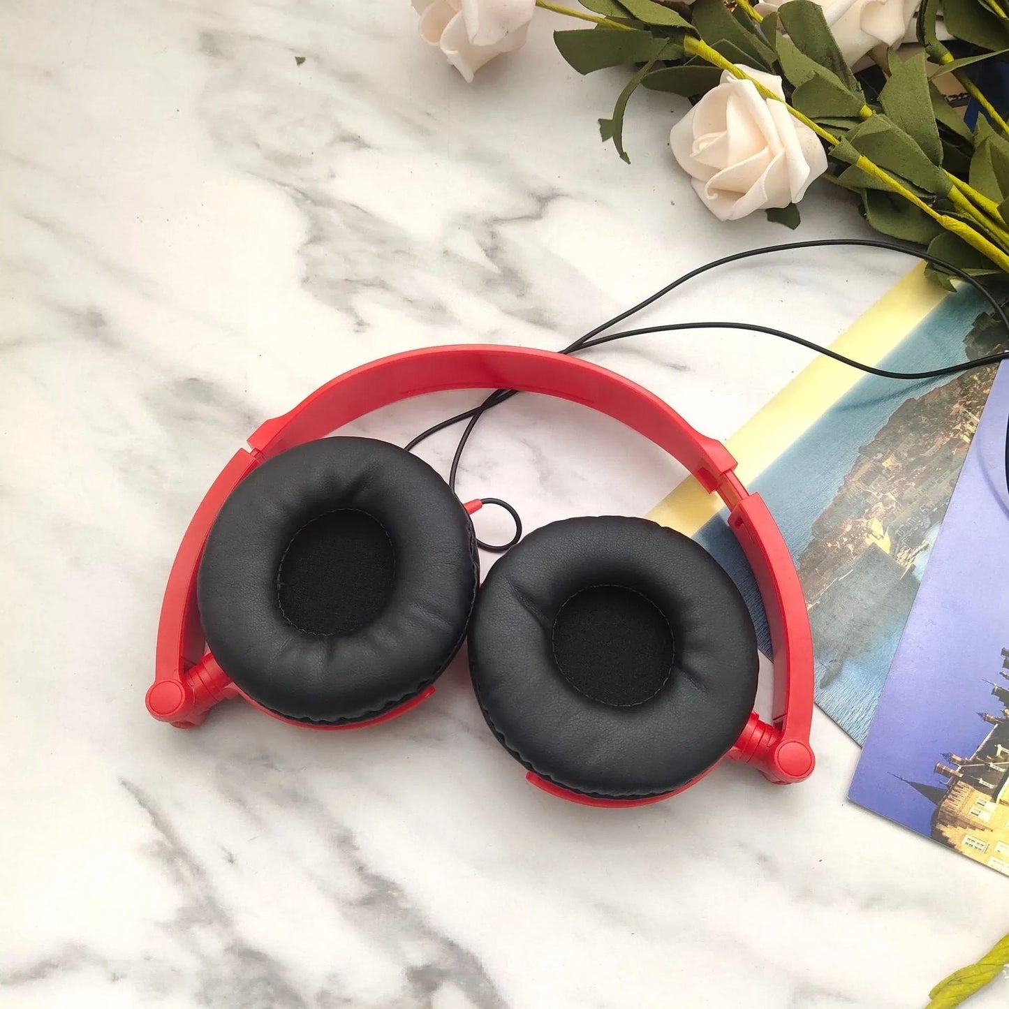 Black folding over-ear wired headphones with adjustable headband and 3.5mm plug on a white background.