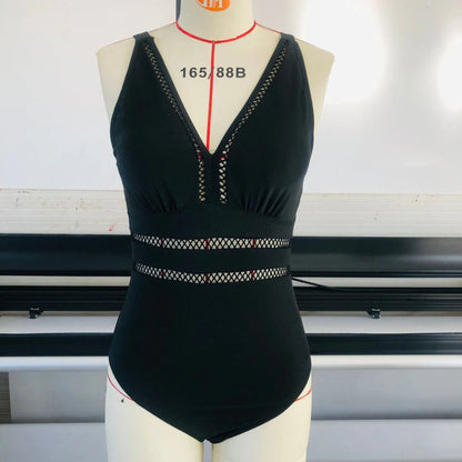 Black plus-size bikini swimsuit with print design and mesh fabric, shown on a hanger.