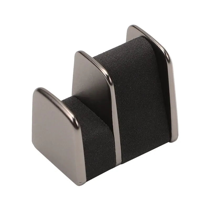 Green zinc alloy and leather glasses clip holder attached to a car dashboard, holding sunglasses.