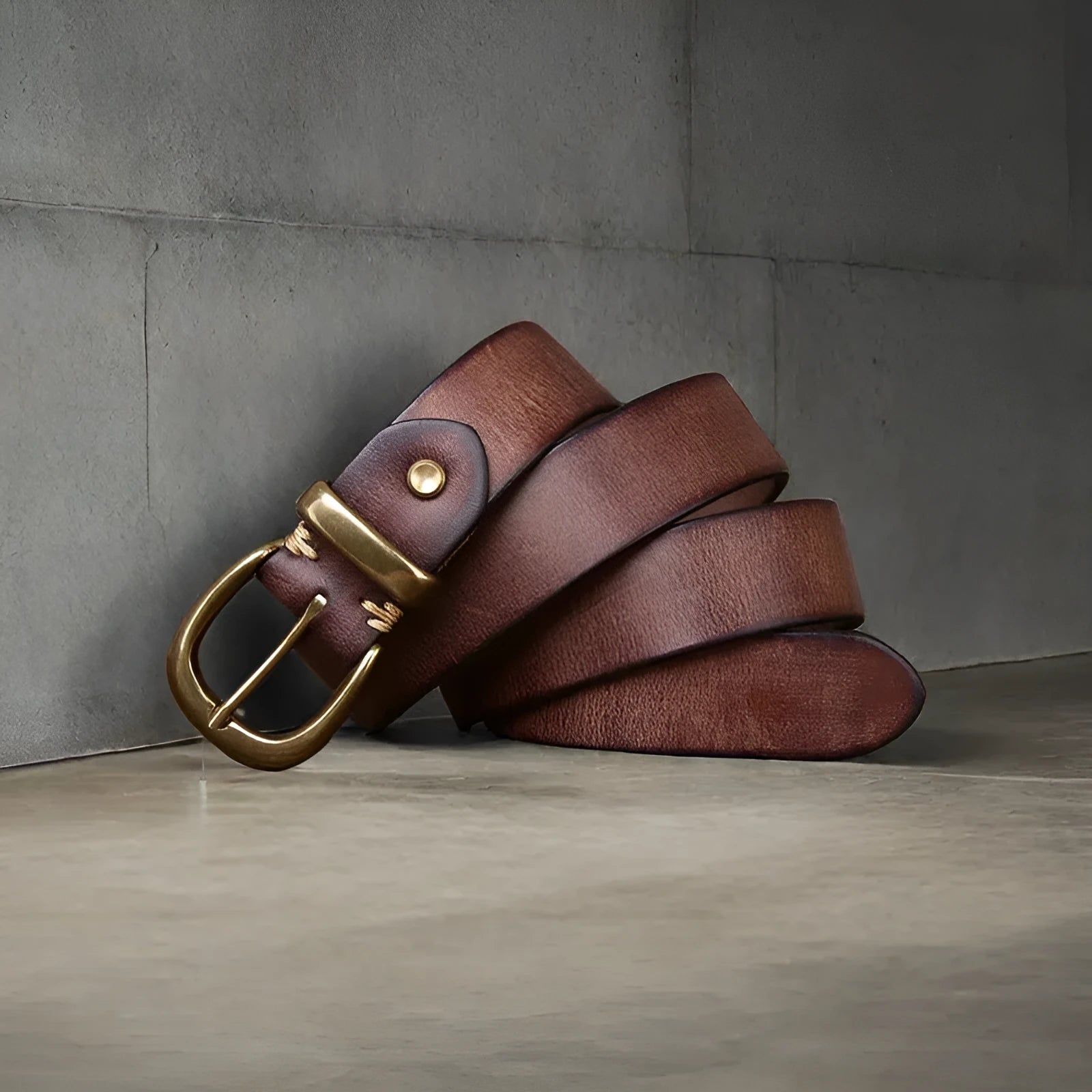 Men's black genuine cattlehide leather belt with a copper pin buckle on a jeans background.