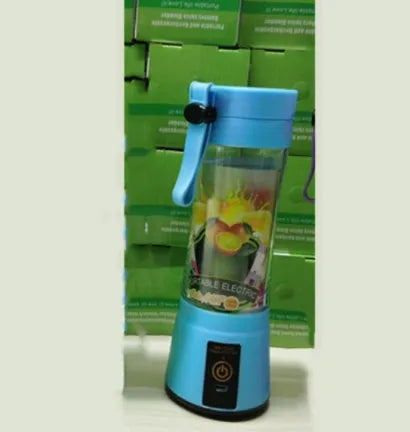 Compact pink portable blender with USB charging cable and box, shown alongside blended fruit smoothie.