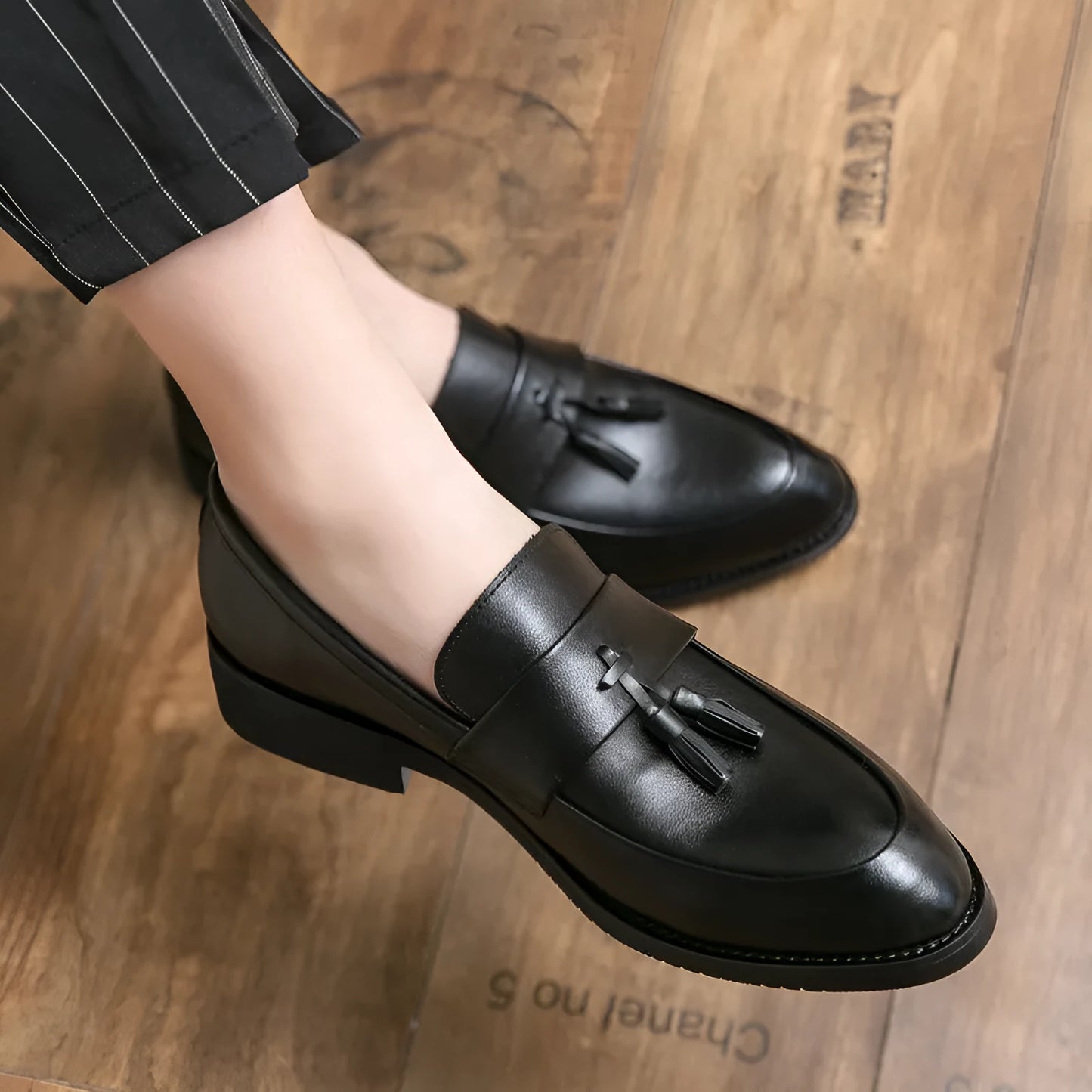 Men's black and brown business casual slip-on shoes with tassel detail and pointed toe