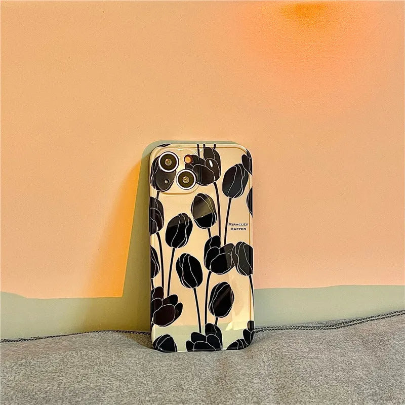 Cold Wind black silicone iPhone case with a white tulip floral pattern on the back.