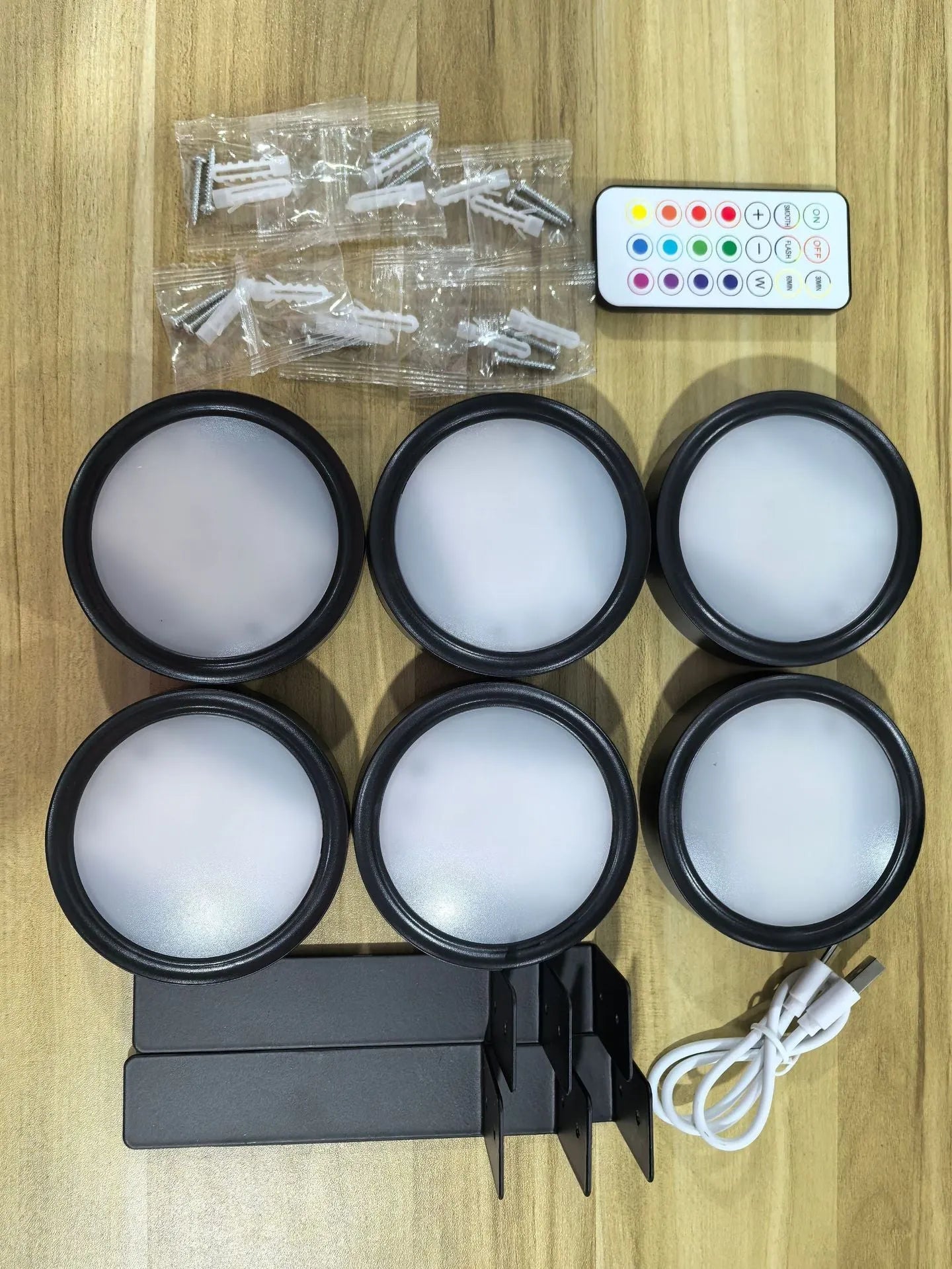 Black magnetic LED painting lamp with remote control on a white wall.