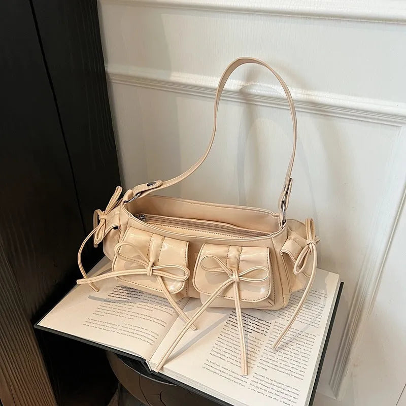 Women's tassel bow shoulder bag in pleated design with multiple pockets, shown in a selected colour.