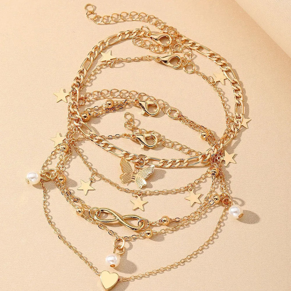 Four-piece women's anklet set with butterfly, pearl, and heart designs in alloy metal