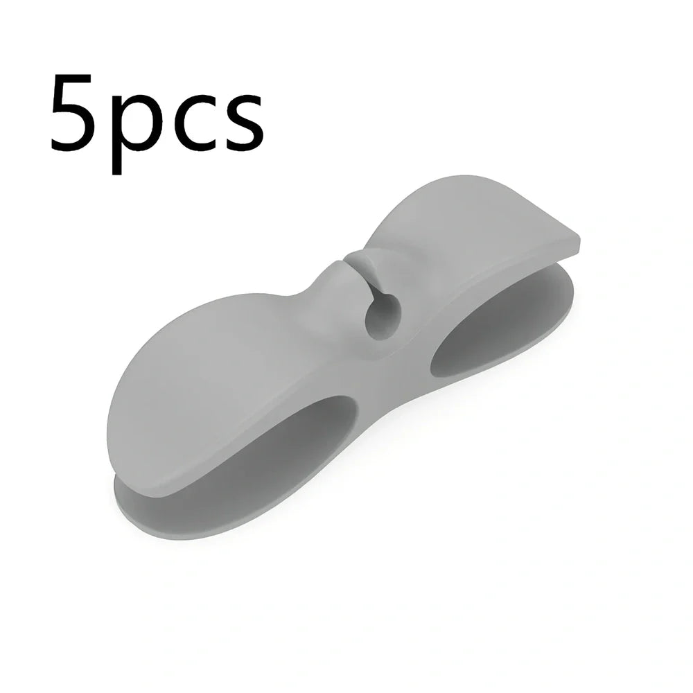 Black TPU cable organizer clips winding appliance cords on kitchen counter, 5cm size, non-marking adhesive for tidy management