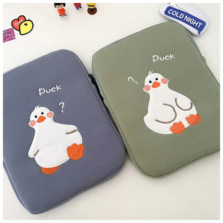 Blue tablet case with embroidered cartoon duck design showing zipper closure and cotton fabric texture
