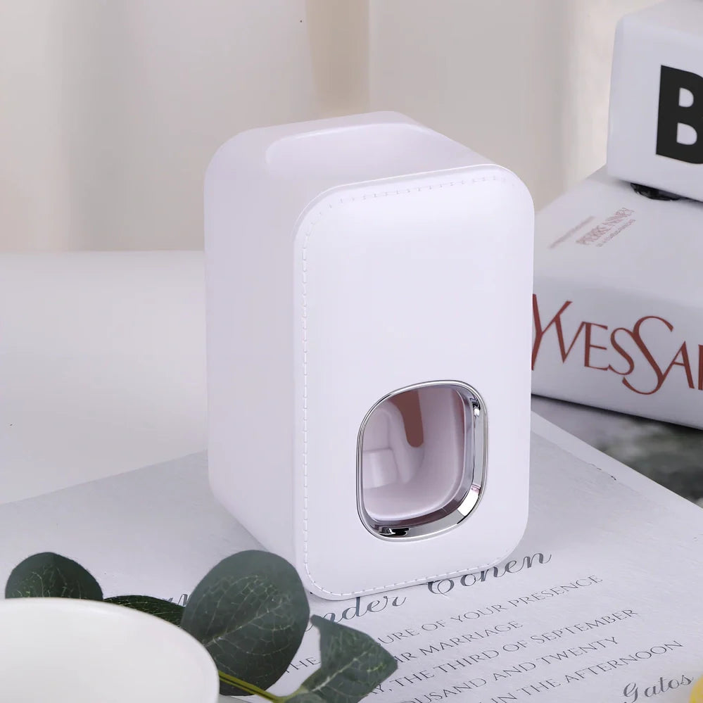White automatic toothpaste dispenser mounted on bathroom wall with precise 0.8g portion dispensing