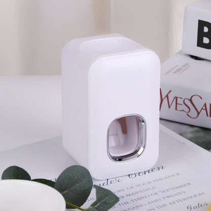White automatic toothpaste dispenser mounted on bathroom wall with precise 0.8g portion dispensing
