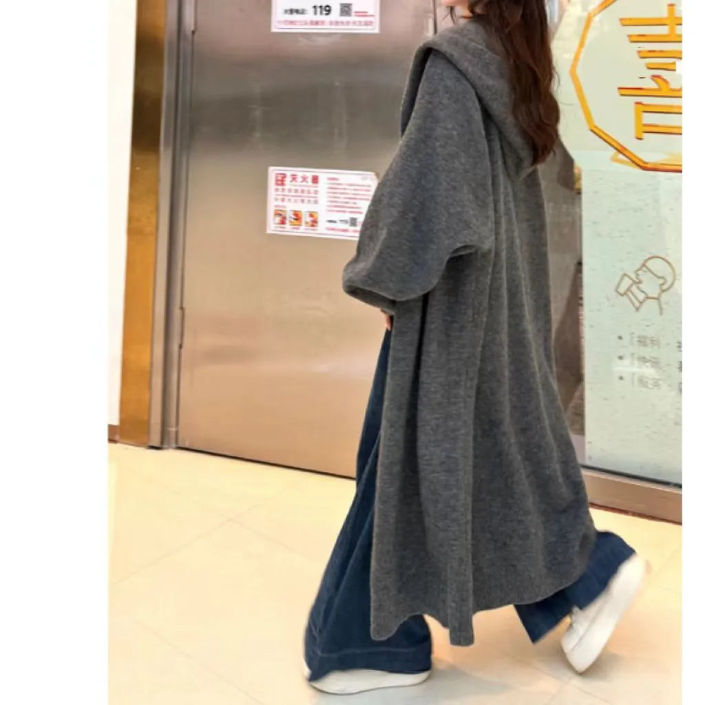 Women's Korean style hooded long knitted cardigan in oatmeal colour, showing loose fit and below-the-knee length