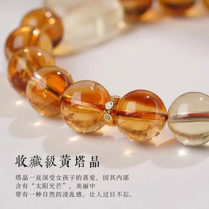 Close-up of a women's carved citrine bracelet with geometric patterns on 10mm crystal beads.
