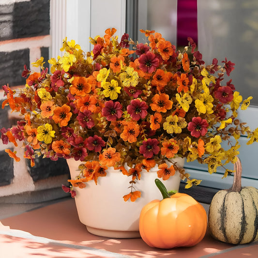 Autumn coloured artificial flower bouquet with plastic and silk flowers for decoration.