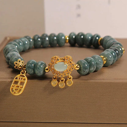 Close-up of a women's bracelet with green emerald jade abacus beads and a silver alloy safety lock clasp.
