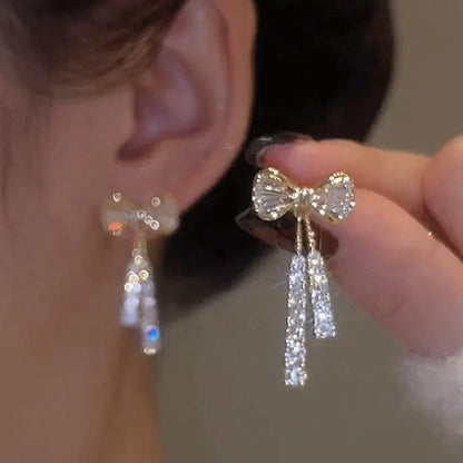 Gold bow-shaped earrings with crystal embellishments, lightweight and elegant