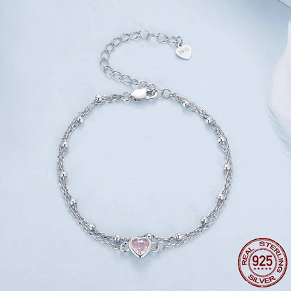 Close-up of a sweet girlish style 925 sterling silver bracelet with a small heart-shaped pendant on an adjustable chain.