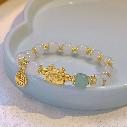 A women's glass glazed bracelet with floral and zodiac animal charms in red, pink, and white pearl beads.