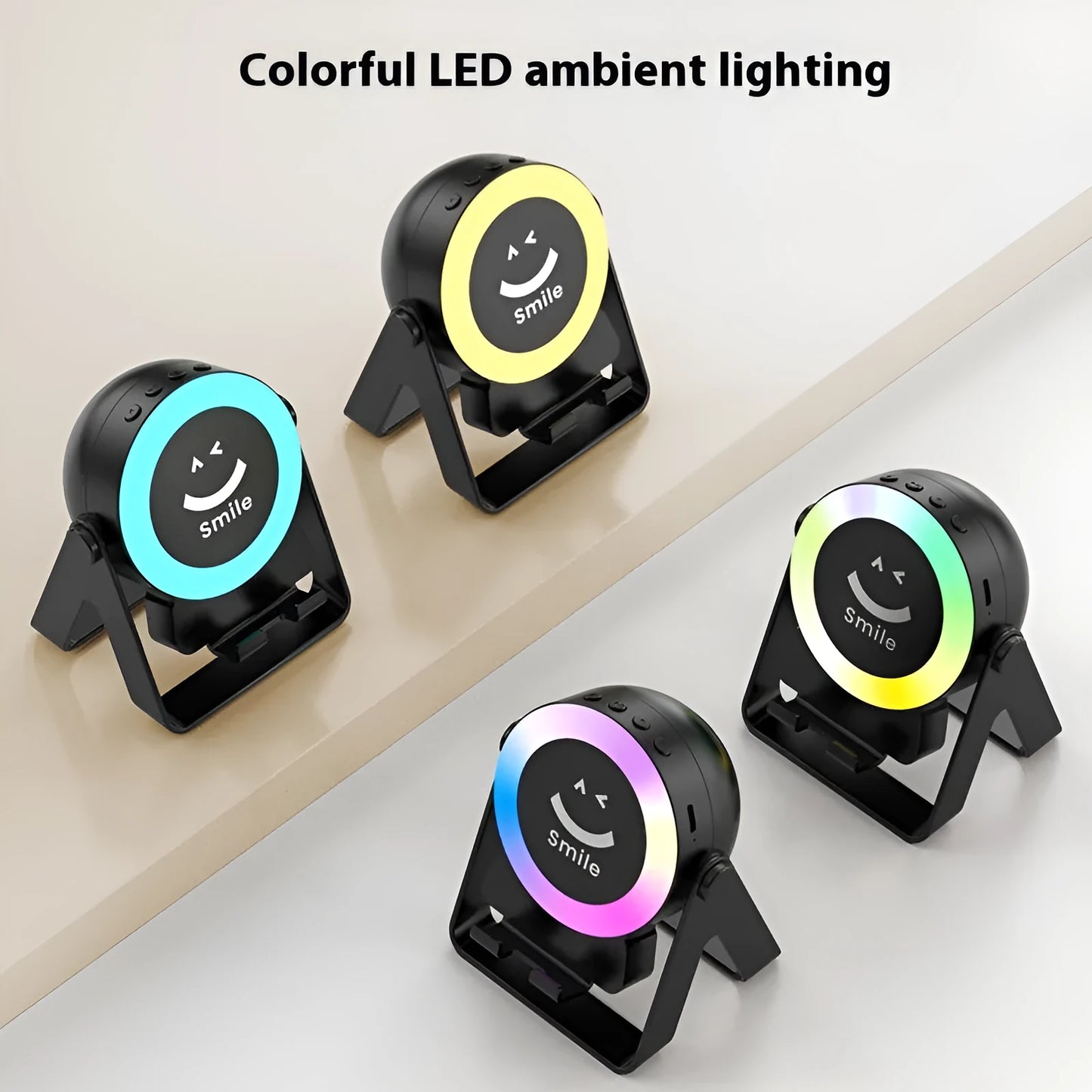 Black and white wireless induction charging Bluetooth speaker with colourful LED lights on a desk.