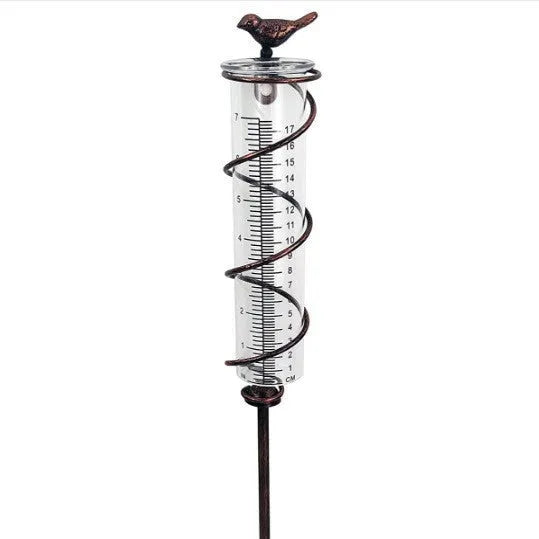 Cast iron hummingbird-shaped rain gauge with glass measurement tube showing 1-20 scale markings