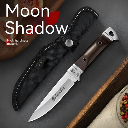 Camping fruit knife with stainless steel blade and brown leather sheath on a wooden surface