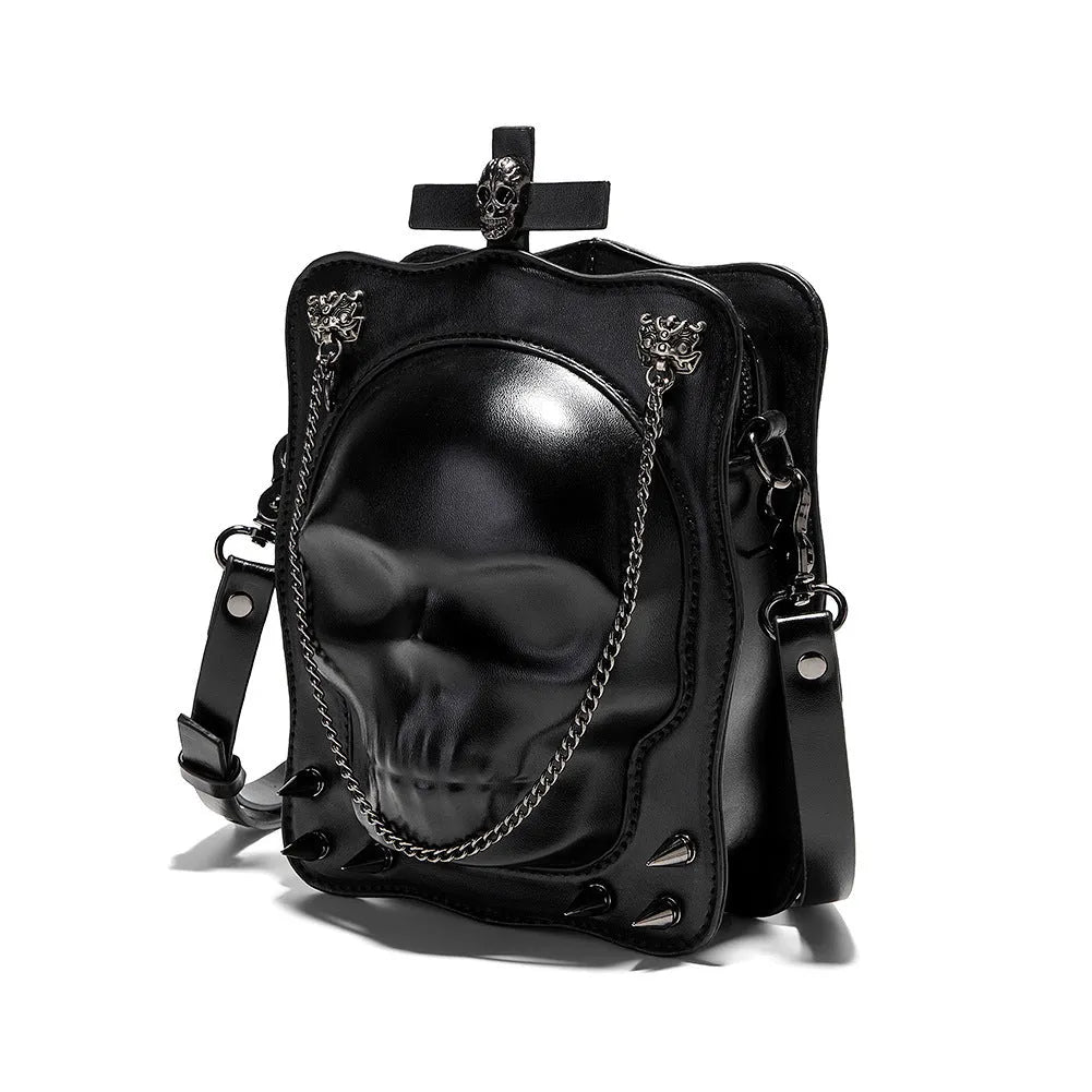 Black mini square messenger bag with embossed skull design, metal chains, and crossbody strap