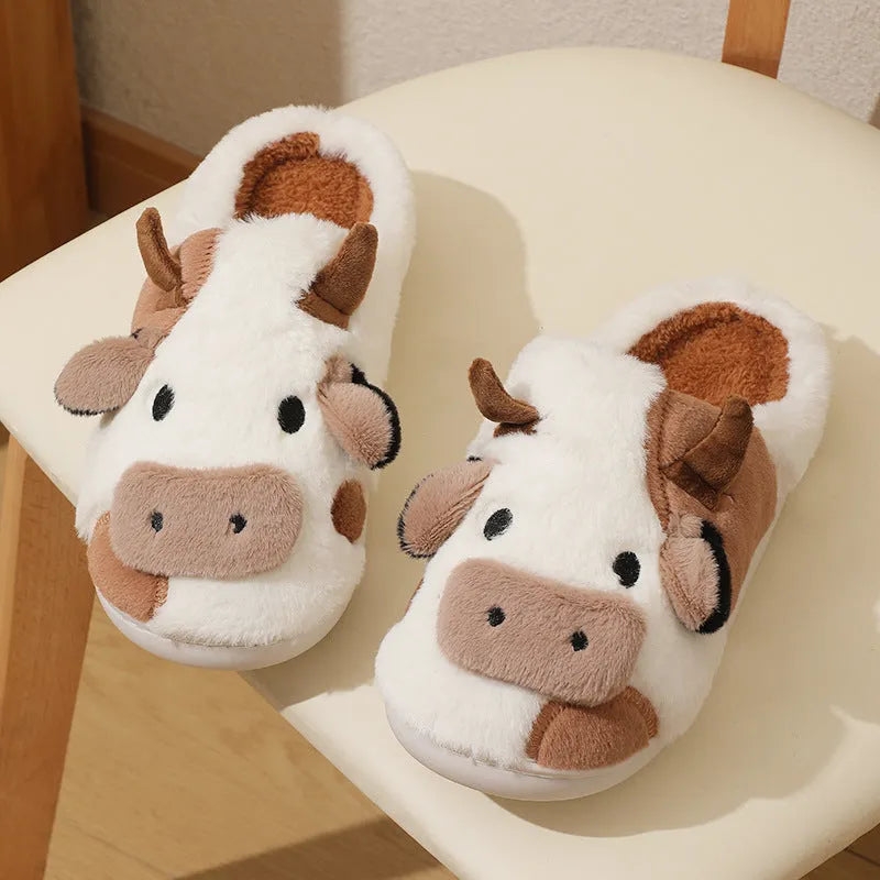 White cow-themed plush slippers with a non-slip textured sole for women.