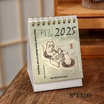 2025 mini desk calendar showing one of four designs: Coffee Time, Awake Time, Corner Perching, or Afternoon Lazy.