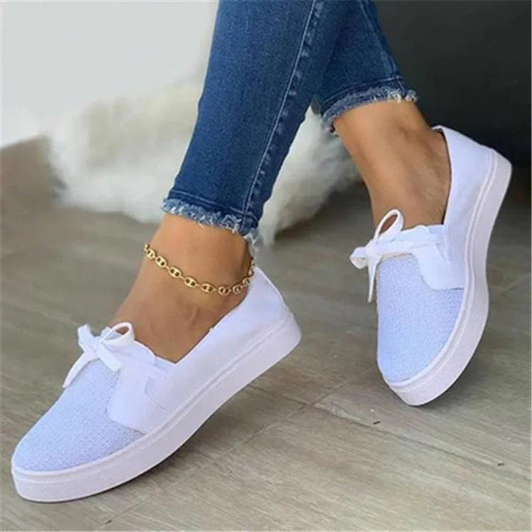Women's white lace-up canvas flat sneakers with cross straps