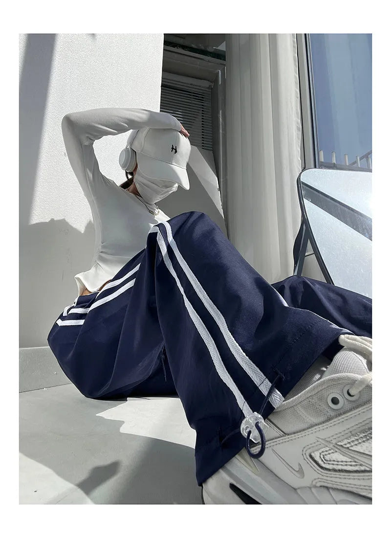 Women's loose straight leg trousers with ribbon parallel bars contrast colour detail on low waist, in thin fabric.