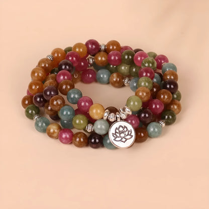 Close-up of a multi-layer beaded bracelet with 108 tourmaline beads and alloy string, showing lotus hanging detail.