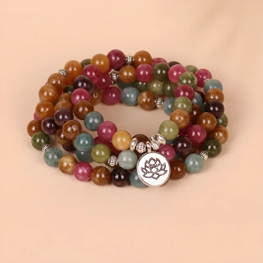 Close-up of a multi-layer beaded bracelet with 108 tourmaline beads and alloy string, showing lotus hanging detail.