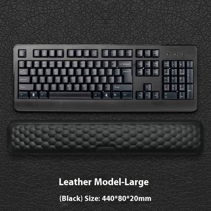 Black and grey memory foam mouse wrist rests with cloth and leather-style covers on a desk.