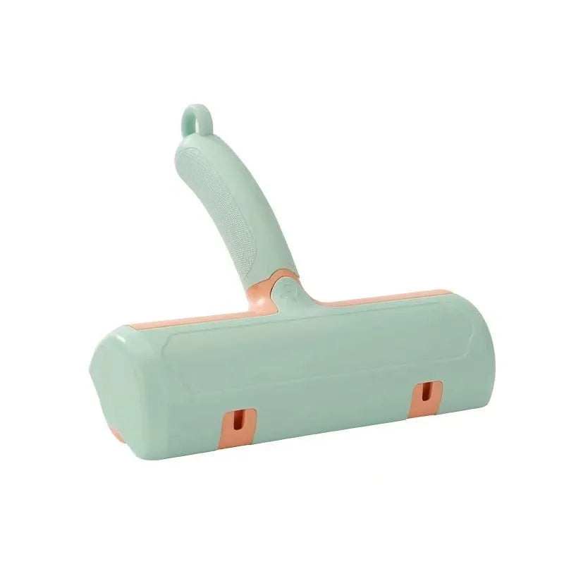 Mint green plastic cat hair removal brush with an ear-style handle on a fabric sofa.