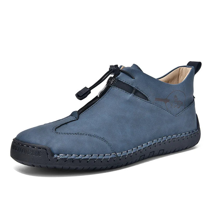 Men's black casual leather shoes with a mid heel, round toe, and visible stitching on a wooden floor.