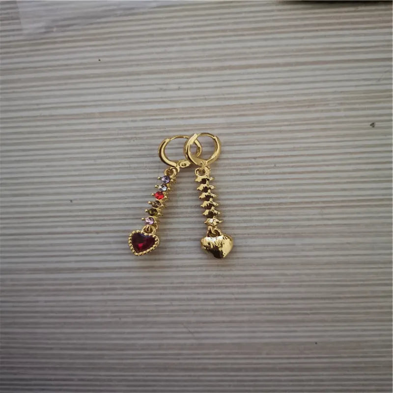 Women's gold and silver heart-shaped alloy drop earrings on a plain background.